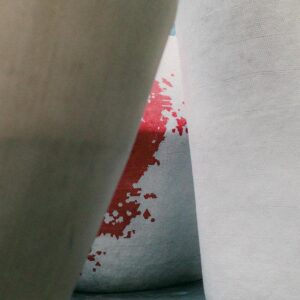 Modern abstract architecture with concrete structures and a splash of red paint detail.