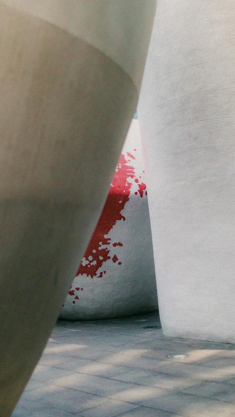 Modern abstract architecture with concrete structures and a splash of red paint detail.